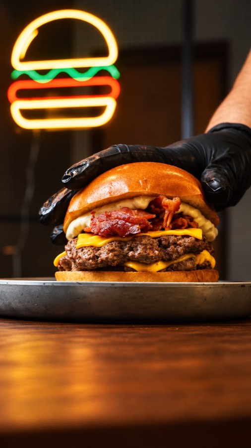 Burger com letreiro de neon ao fundo